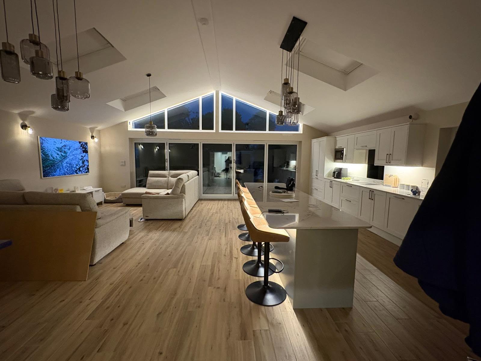 Kitchen extension with pendant cluster and LED-strip skylight reveal