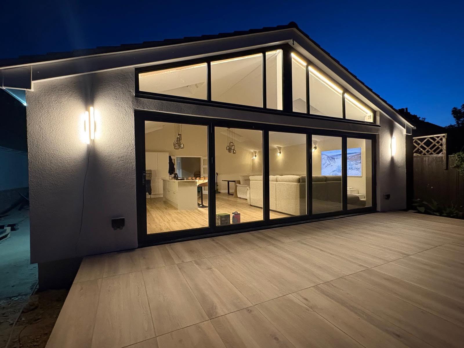 A modern Bognor Regis home at dusk lit by Swann Electrical's interior and exterior lighting installation